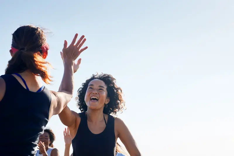 Zwei Frauen geben sich ein High-Five.